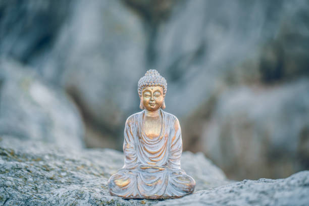 istock Peaceful gold Buddha figure sitting on a rock surrounded by mountains 1307439917