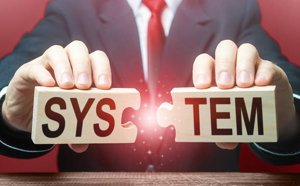 istock Man breaks the puzzle with word System. Destruction of system and foundations, creating a situation of chaos. Bypassing protection and hacking networks. Change of power. Security breach, vulnerability 1307443517