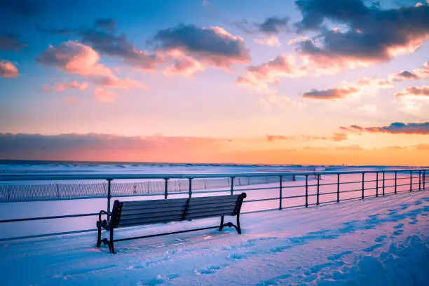 Photo of Winter Beach Scene with Snow at Sunset