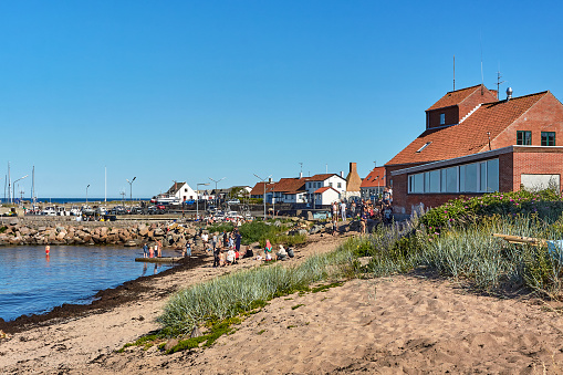 Aarsdale, Bornholm island, Denmark - June 28, 2019. Local people and tourists celebrating official opening of Mikkeller Aarsdale bar and pub by the port in Aarsdale.