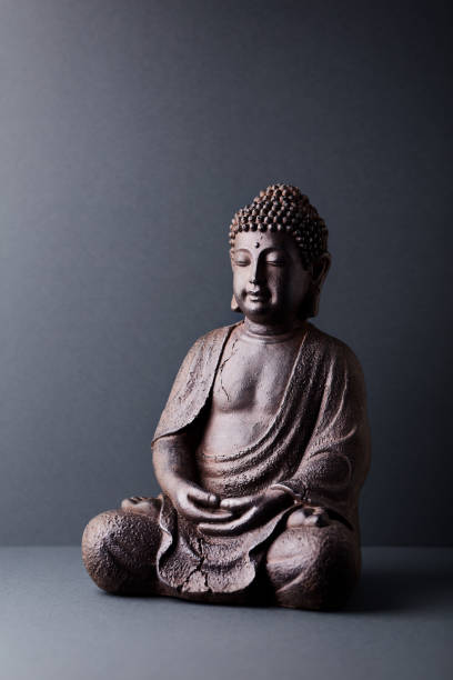 istock Meditating Buddha Statue on paper background. Copy space. 1307450098