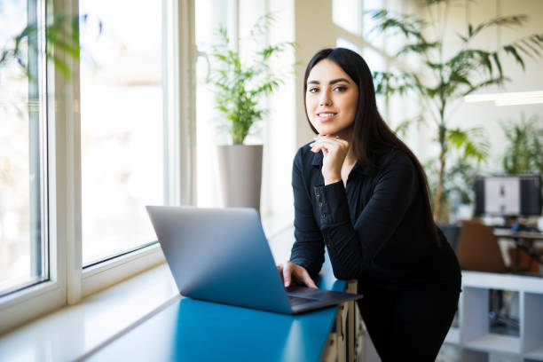 istock Concentrated young beautiful business woman working on laptop in modern office 1307450708