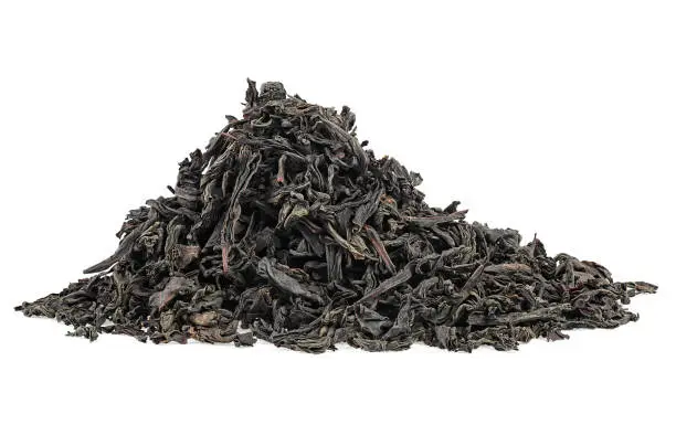 Dry black tea leaves isolated on a white background. Pile of black tea. Large leaf black tea.