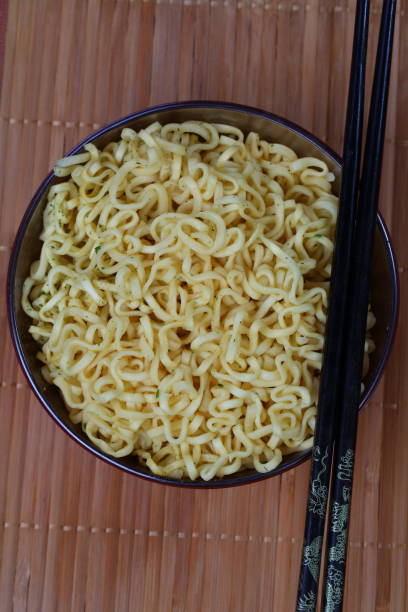 istock Chinese noodles with chopsticks on red background 1307451358