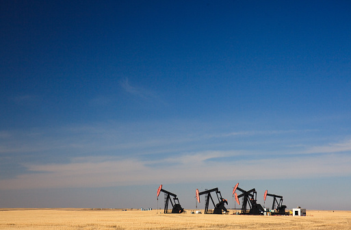 Five oil pumpjacks in southern Alberta, Canada. This oilfield is located near Lethbridge.