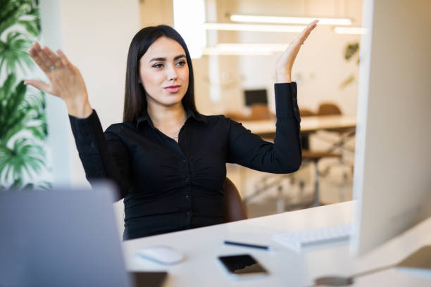 troppo lavoro. giovane bella donna con le mani alzate davanti al pc dello schermo seduto in ufficio - problems computer pc frustration foto e immagini stock