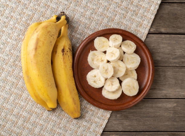 istock Bananas and slices on a plate over wooden table 1307452534