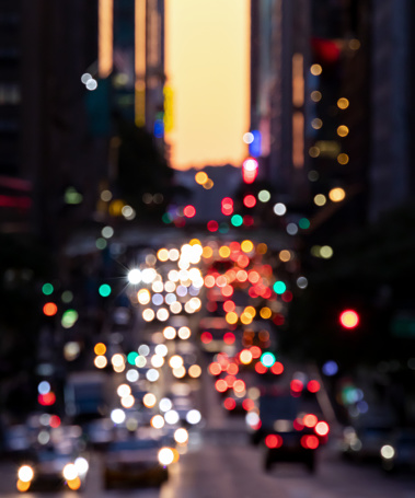 Blurred lights from cars in crosstown traffic through the buildings of Midtown Manhattan in New York City NYC