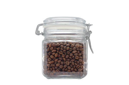 A glass jar filled with coffee beans and closed with a clip-on lid. Isolated on light gray background.