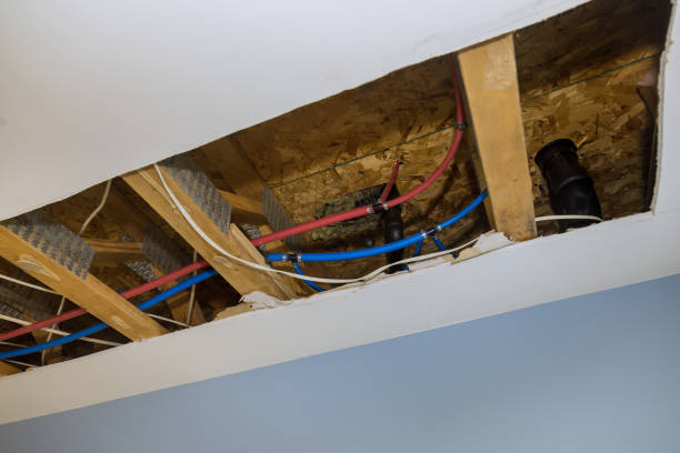 istock Repair plumbing line with a leaking pipe in a ceiling 1307454821