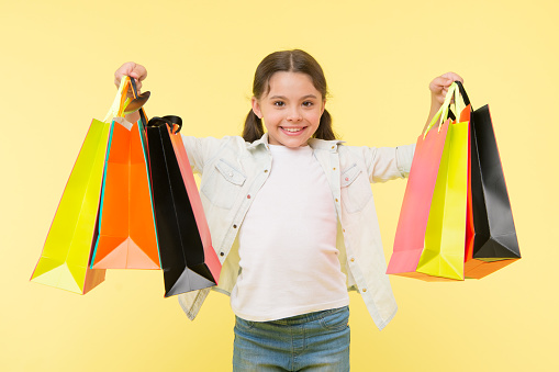 Best discounts and promo codes. Back to school season great time to teach budgeting basics children. Girl carries shopping bags. Prepare for school season buy supplies stationery clothes in advance.