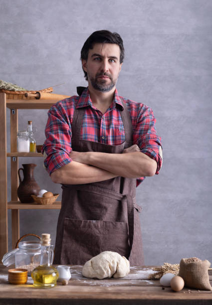 istock Baker man kneading or making dough and bakery ingredients for homemade bread cooking on shelf 1307455183
