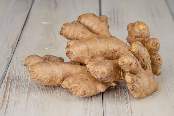 istock Fresh, light, healthy ginger on white wooden background. 1307456245