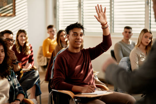 教室での探求に答えるために腕を上げる幸せな黒人学生。 - lecture hall college student university multi ethnic group ストックフォトと画像