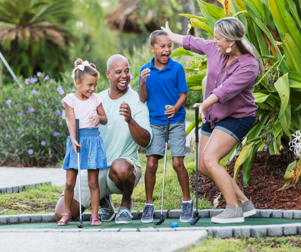 istock Interracial family, two children playing miniature golf 1307457773