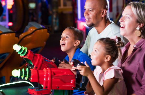 istock Mixed race family playing game at video arcade 1307457780