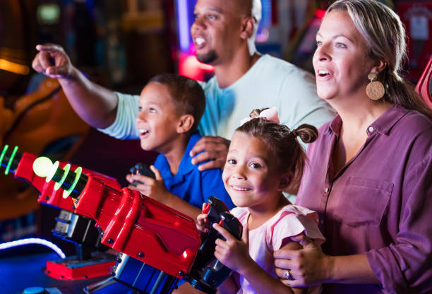 istock Mixed race family playing game at video arcade 1307457790
