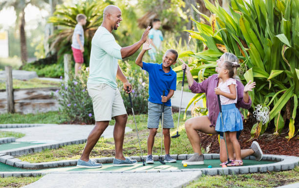 istock Interracial family, two children playing miniature golf 1307457804