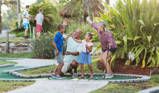 istock Interracial family, two children playing miniature golf 1307457819