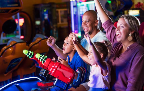 istock Mixed race family playing game at video arcade 1307457854