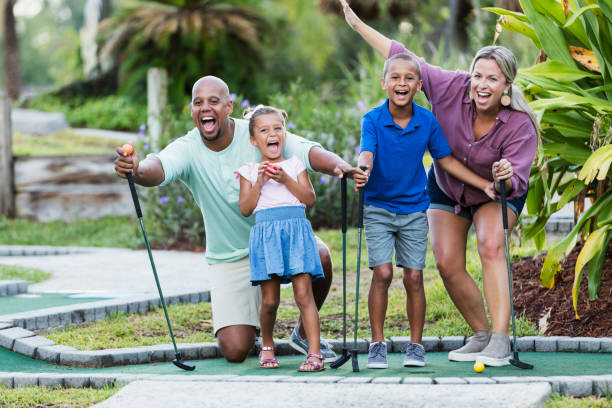 istock Interracial family, two children playing miniature golf 1307457877
