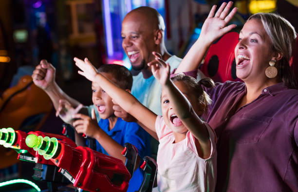 istock Mixed race family playing game at video arcade 1307457898