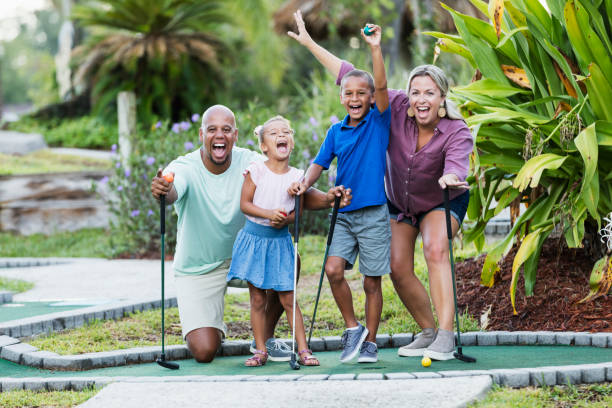 istock Interracial family, two children playing miniature golf 1307457923
