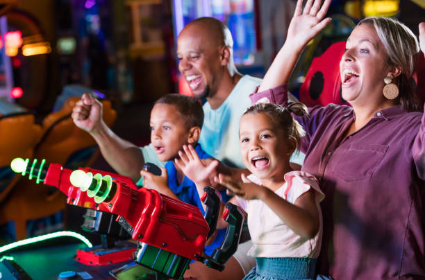 istock Mixed race family playing game at video arcade 1307457926