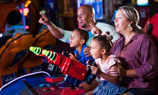 istock Mixed race family playing game at video arcade 1307457928