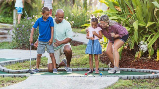 istock Interracial family, two children playing miniature golf 1307457938