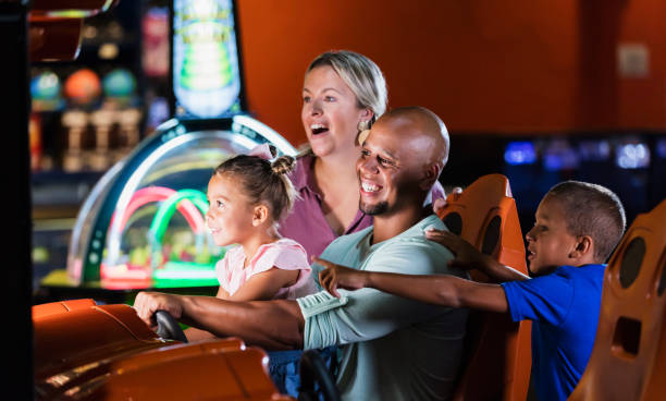 istock Mixed race family playing game at video arcade 1307458493