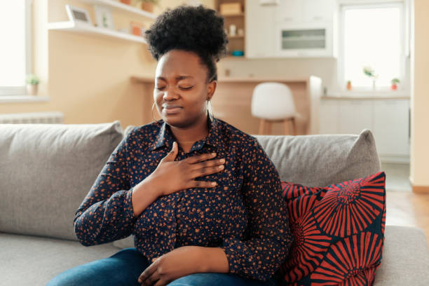 This does not feel normal Pressure in the Chest. Close-up Photo of a Stressed Obese African American Woman Who Is Suffering From a Chest Pain and Touching Her Heart Area. heart disease photos stock pictures, royalty-free photos & images