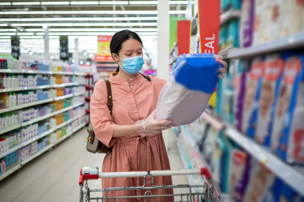 mujer embarazada comprando artículos para bebés y suministro en un hipermercado irreconocible - diaper shopping human pregnancy supermarket fotografías e imágenes de stock