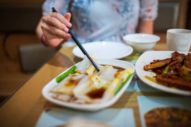 istock Woman having Steamed Rice Noodle Rolls set in an restaurant 1307459024