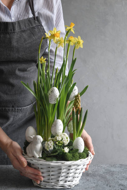 istock Easter table centerpiece with festive eggs, moss and bunny. Spring floral workshop. 1307460081