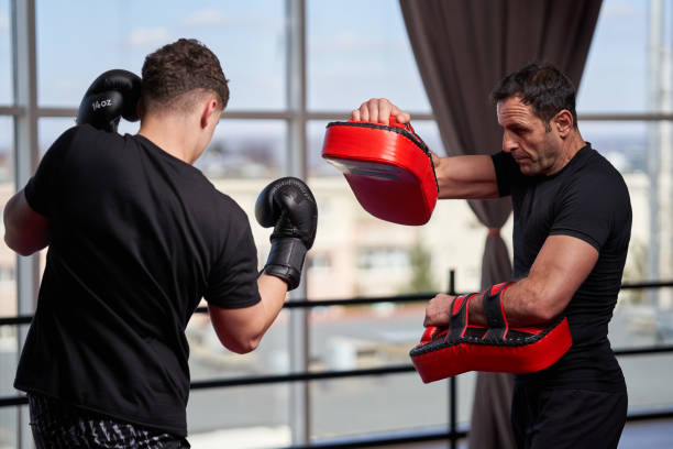 istock Kickboxing fighter hitting pads with trainer 1307463020