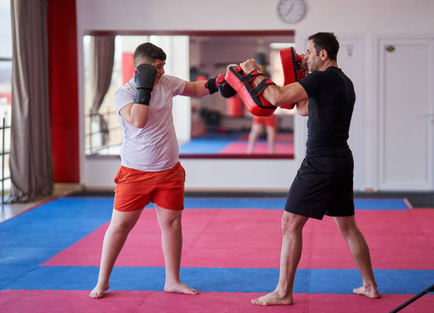 istock Overweight kickboxer with his trainer 1307463058