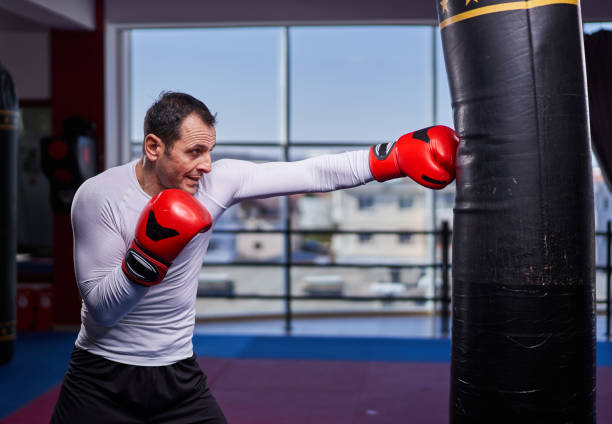 istock Kickboxer hitting the heavy bag in the gym 1307463295