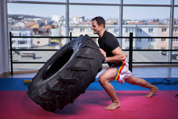 istock Kickboxer doing tire flips in the gym 1307463296