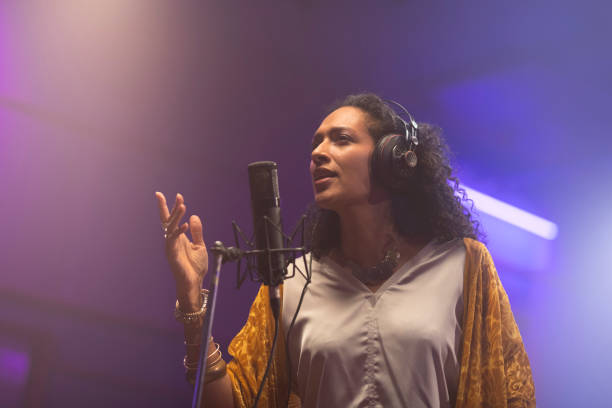 istock Female singer singing in recording studio 1307464317