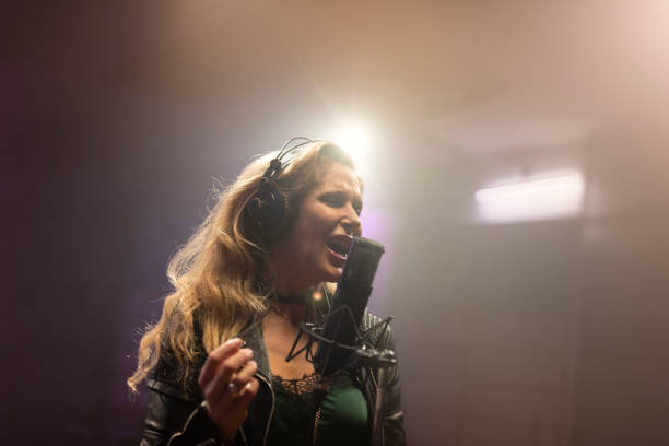 istock Female singer singing in recording studio 1307464338