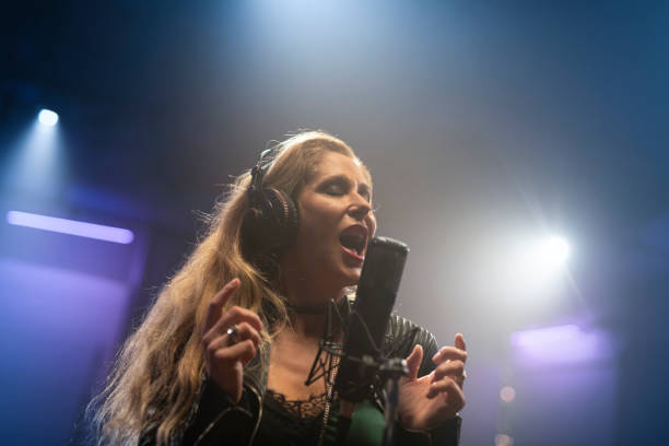 istock Female singer singing in recording studio 1307464431