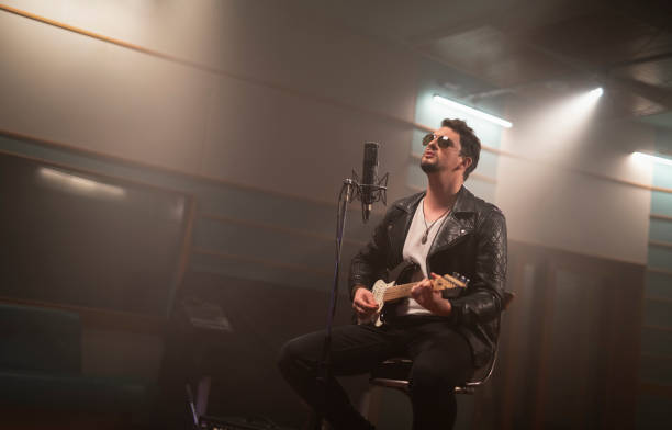 istock Male singer playing guitar 1307464448