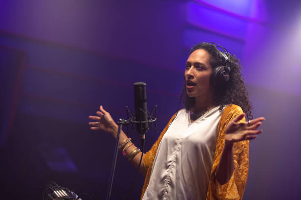istock Female singer singing in recording studio 1307464492