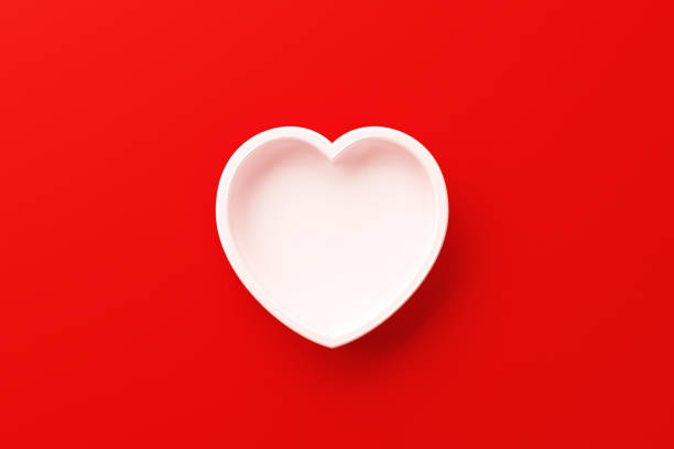 istock White Heart Shape Sitting On Red Background 1307464956