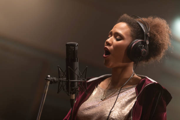 istock Female singer singing in recording studio 1307465094