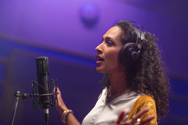 istock Female singer singing in recording studio 1307465113