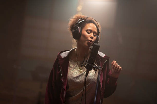 istock Female singer singing in recording studio 1307465126