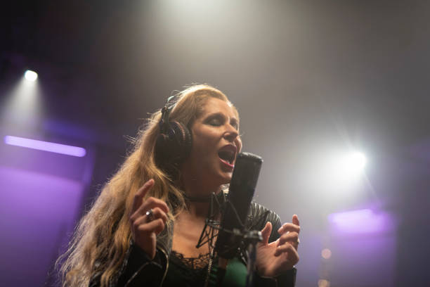 istock Female singer singing in recording studio 1307465146