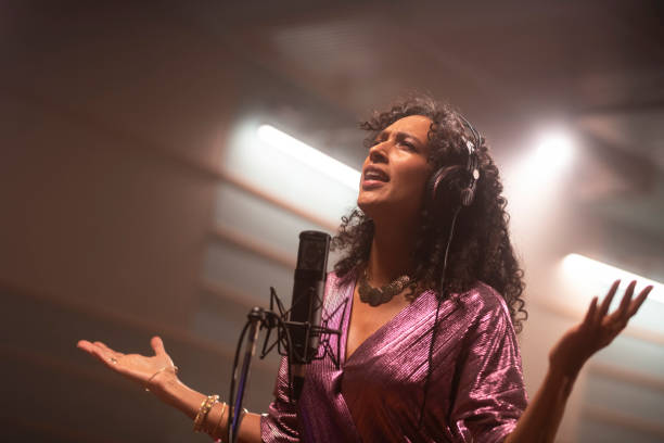 istock Female singer singing in recording studio 1307465159